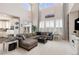 Spacious living room featuring high ceilings, large windows with shutters and a comfortable sectional sofa at 3554 E 143Rd Pl, Thornton, CO 80602