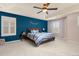 Tranquil bedroom featuring a tray ceiling, ceiling fan, and a lovely accent wall at 3554 E 143Rd Pl, Thornton, CO 80602