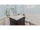 Charming powder room with a stylish vanity, decorative mirror, and light blue walls with elegant wainscoting at 3554 E 143Rd Pl, Thornton, CO 80602