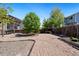 Gravel backyard featuring a fenced yard, mature trees, and a covered patio at 11370 Iola St, Commerce City, CO 80640