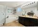 Bathroom with a dual sink vanity, large soaking tub, separate glass-enclosed shower at 11370 Iola St, Commerce City, CO 80640