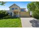 Traditional two-story home with a well-manicured lawn and a two-car garage at 11370 Iola St, Commerce City, CO 80640