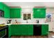 Close up of the modern kitchen showcasing the green cabinets, white subway tile, and updated appliances at 11370 Iola St, Commerce City, CO 80640