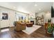 Inviting living room features hardwood floors, fireplace, and a large window for natural light at 11370 Iola St, Commerce City, CO 80640