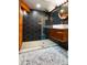 Sleek bathroom with dark hexagonal tile, a walk-in shower, and copper accents at 4425 King St, Denver, CO 80211