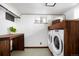 Basement laundry room with modern washer and dryer, and wood shelving at 4425 King St, Denver, CO 80211