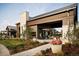 Stunning modern home with manicured landscaping, stone accents, and covered outdoor dining space at 1962 Canyonpoint Ln, Castle Pines, CO 80108