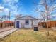 Backyard showing the detached garage, swing set, and the garden beds, with grass and gravel throughout at 1681 Nome St, Aurora, CO 80010