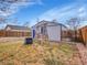 Fenced backyard features a shed, a swing set, lawn and gravel cover creating a relaxing and functional space at 1681 Nome St, Aurora, CO 80010