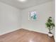 Bedroom featuring wood flooring, large window, and plant in white pot at 1681 Nome St, Aurora, CO 80010