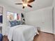 Bedroom with wood floors, blue throw blanket, ceiling fan and large windows offering ample light at 1681 Nome St, Aurora, CO 80010