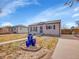 Charming single-story home boasts curb appeal with blue garden pots and American flag on a sunny day at 1681 Nome St, Aurora, CO 80010