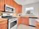 Well-equipped kitchen features wooden cabinets, stainless steel appliances, and tiled backsplash at 1681 Nome St, Aurora, CO 80010