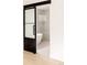 Stylish bathroom showcases a modern soaking tub and glass enclosed shower with a sliding frosted glass barn door at 4322 Quivas St, Denver, CO 80211