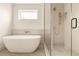 Modern bathroom features a standalone soaking tub and glass enclosed shower, providing a luxurious experience at 4322 Quivas St, Denver, CO 80211