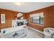 Cozy home office featuring wood paneling, fireplace, large window overlooking the yard, and comfortable seating at 38 Hillside Dr, Wheat Ridge, CO 80215