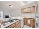 Kitchen featuring a stainless steel sink, white appliances, and light wood cabinets at 11103 E Alameda Ave # 102, Aurora, CO 80012