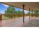 Spacious wooden deck featuring multiple support beams and railings with tree views at 11035 E Parker Rd, Parker, CO 80138