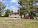 Rear exterior view of home showing partial deck, yard, and large, mature shade trees at 11035 E Parker Rd, Parker, CO 80138