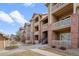 Inviting multi-story condo building featuring balconies, brick accents, and well-maintained landscaping at 1632 W Canal Cir # 924, Littleton, CO 80120