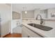 Bright kitchen with stainless steel sink, white cabinetry and view to the living area at 1632 W Canal Cir # 924, Littleton, CO 80120