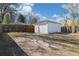 View of a backyard featuring a detached garage and a wood fence, with partial tree shade at 2570 Jay St, Edgewater, CO 80214