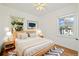 Sunlit bedroom with a ceiling fan, two windows, and a comfortable queen bed at 2570 Jay St, Edgewater, CO 80214