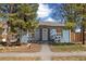 Charming single-story home with blue siding, white trim, manicured landscaping, and mature trees at 2570 Jay St, Edgewater, CO 80214