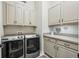Functional laundry room with modern washer and dryer, ample cabinet storage, and stylish decor at 5506 Water Avens Dr, Castle Rock, CO 80104