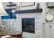 Close-up of a stone fireplace with a wooden mantle and built-in cabinets in the living room at 5506 Water Avens Dr, Castle Rock, CO 80104