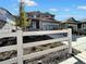 Two-story home with gray siding and a white picket fence; sales center sign visible at 4525 Cholla Trl, Castle Rock, CO 80104