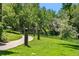 Green community walking path lined with tall grasses and mature trees at 8039 Lee Dr # 2, Arvada, CO 80005