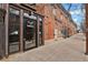 Charming red brick building entrance with glass windows and door, showcasing the Bag Factory Lofts at 2715 Blake St # 304, Denver, CO 80205