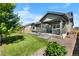Beautiful backyard with green grass, a stone patio, a covered porch, and exterior view of the house at 15920 Buffalo Run Dr, Commerce City, CO 80022