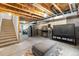Unfinished basement featuring exposed wood ceiling, concrete floors and walls, and exercise equipment at 15920 Buffalo Run Dr, Commerce City, CO 80022