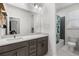 Well-lit bathroom featuring gray vanity with white countertop, modern fixtures and a shower-tub combo at 15920 Buffalo Run Dr, Commerce City, CO 80022