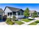 Charming two-story home with a cozy front porch, manicured lawn and beautiful landscaping at 15920 Buffalo Run Dr, Commerce City, CO 80022