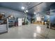 Garage with epoxy flooring, blue painted walls and ceiling, storage shelves and fridge at 15920 Buffalo Run Dr, Commerce City, CO 80022