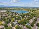 Panoramic aerial view of homes nestled among lush trees near a serene lake and open fields at 3145 Stevens Cir, Erie, CO 80516