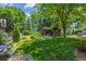 Expansive backyard with lush lawn, mature trees, picturesque pond, and vine-covered pergola seating area at 3145 Stevens Cir, Erie, CO 80516