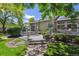 Serene backyard deck with dining set, mature trees, and meticulous landscaping for outdoor enjoyment at 3145 Stevens Cir, Erie, CO 80516