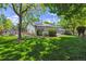 Expansive backyard view showcasing the home's exterior, beautiful lawn, mature trees, gazebo, and rear deck at 3145 Stevens Cir, Erie, CO 80516