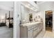 Bathroom with double sinks, large mirror, and walk in closet at 3145 Stevens Cir, Erie, CO 80516