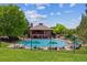 Community pool surrounded by lounge chairs, umbrellas, a fence, and a well-maintained lawn at 3145 Stevens Cir, Erie, CO 80516