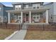 Two-story home exterior with front porch, brick accents, and black metal fence at 10092 Flower St, Broomfield, CO 80021
