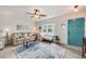 Bright living room featuring a comfortable couch, large window, stylish rug, and a decorative blue front door at 3058 W 134Th Way, Broomfield, CO 80020