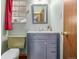 Cozy bathroom featuring a blue vanity, a marble countertop, and a window at 305 Titan St, Aurora, CO 80011