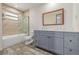 Bathroom featuring grey dual sink vanity, tub, and marble countertop at 305 Titan St, Aurora, CO 80011