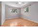 Simple bedroom featuring hardwood floors, and two bright windows overlooking the greenery at 305 Titan St, Aurora, CO 80011
