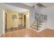 Bright foyer featuring hardwood floors and staircase with decorative iron railing at 305 Titan St, Aurora, CO 80011